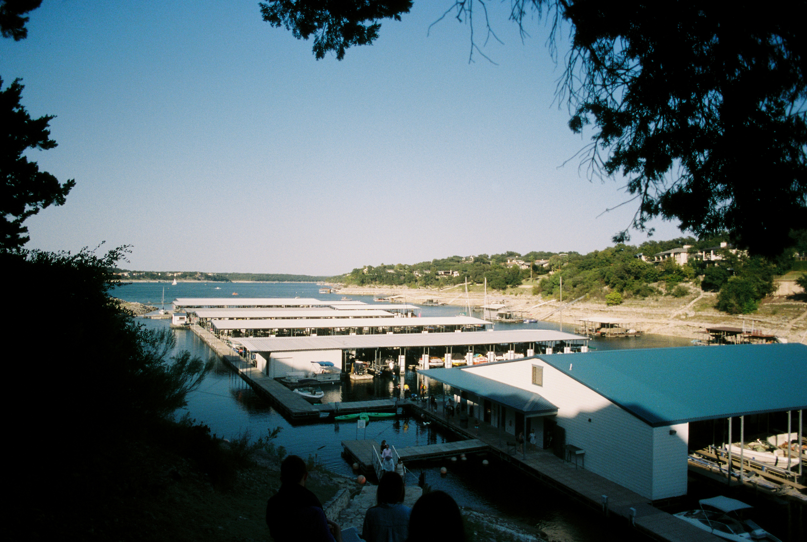 Boat cruising on Lake Travis near Austin with houses along the shoreline