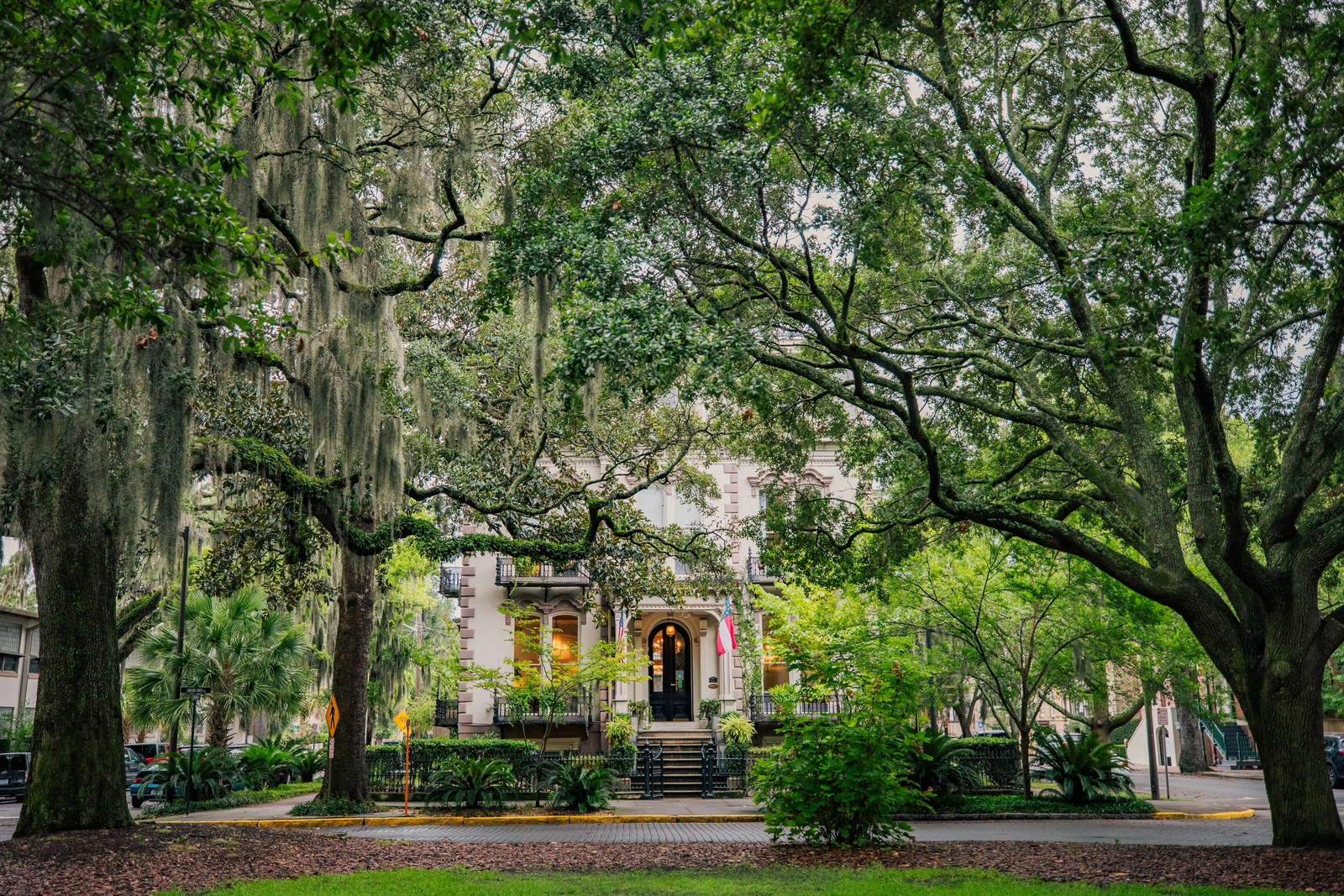 Oak-lined street with Spanish moss leading to a historic Savannah building
