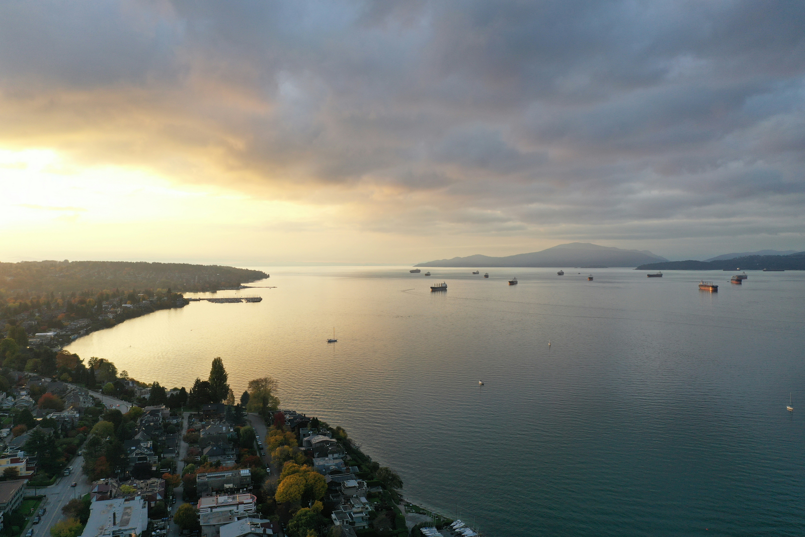 Sunset view over Vancouver's waterfront with boats anchored in the bay